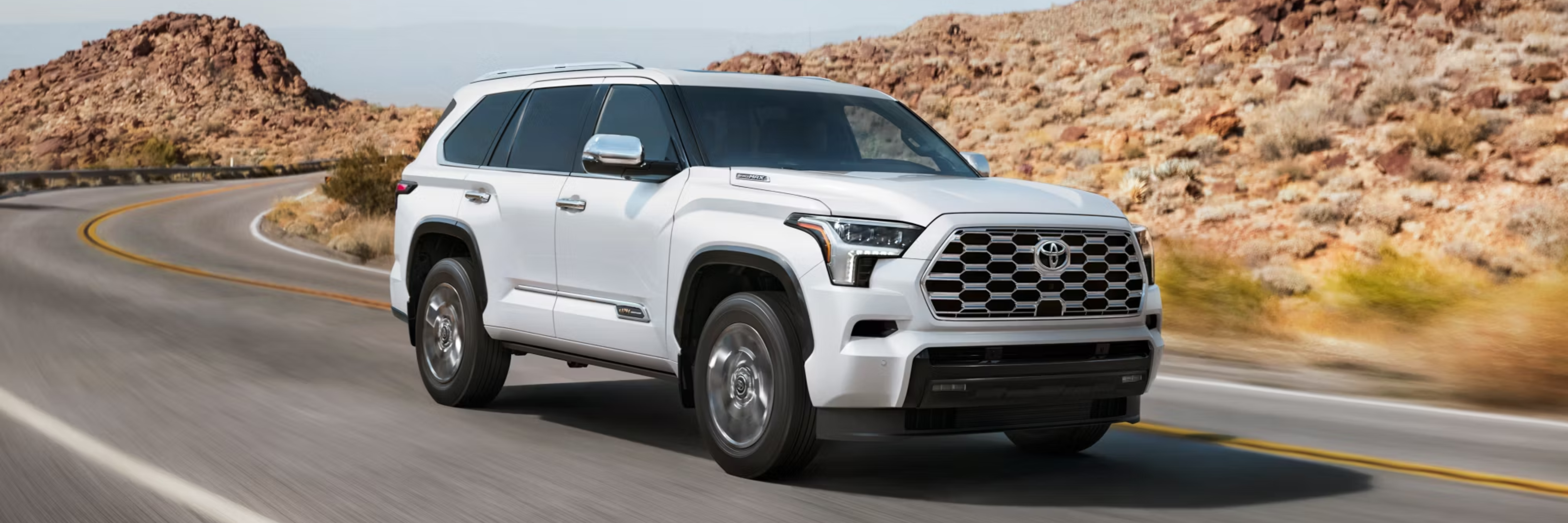 the 2025 toyota land cruiser is driving down a mountain road